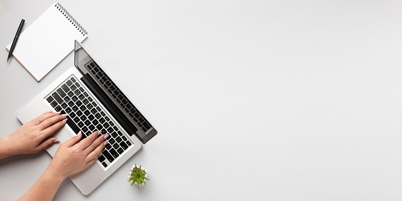 Vista dall'alto di una ragazza che scrive con la tastiera del computer portatile